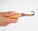 Hand holding a wooden tool with a metal tip on a white background