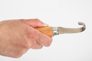 Hand holding a wooden-handled knife with a white background